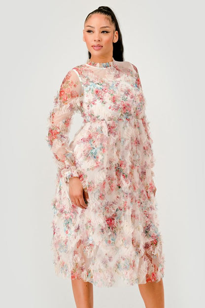 A woman in an elegant floral midi dress with sheer long sleeves, a high neck, and textured ruffled details for a romantic look.