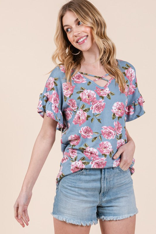 Woman in blue floral top with pink rose print on beige background