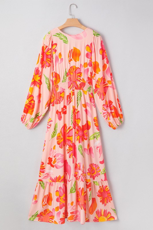 A flowy maxi dress with a vibrant floral print in pink, orange, and green.