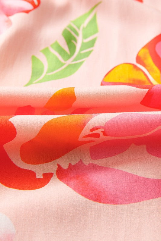 A flowy maxi dress with a vibrant floral print in pink, orange, and green.