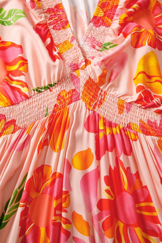 A flowy maxi dress with a vibrant floral print in pink, orange, and green.