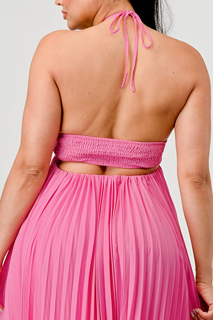 The image shows a woman with dark skin and long black hair wearing a hot pink, strapless maxi dress with a pleated skirt and a sweetheart neckline.