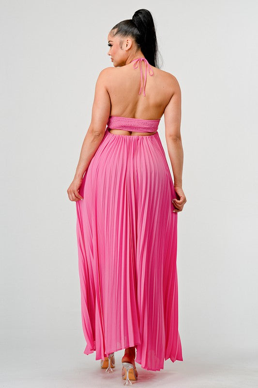 The image shows a woman with dark skin and long black hair wearing a hot pink, strapless maxi dress with a pleated skirt and a sweetheart neckline.