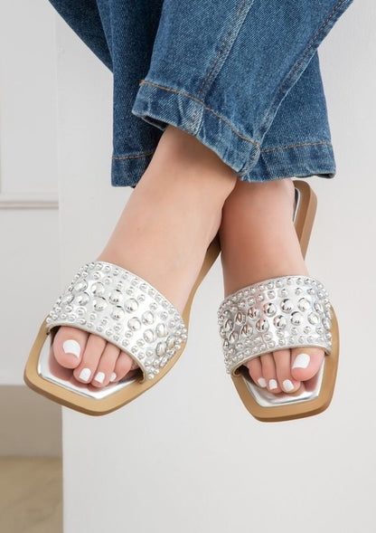 Slip-on sandals with pearl and stud embellished upper band, square toe silhouette, flat sole, and open-toe design