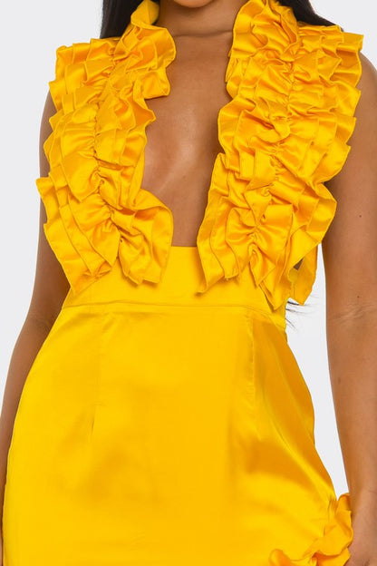 A bright yellow, one-shoulder dress with ruffle detailing along the neckline and a high side slit