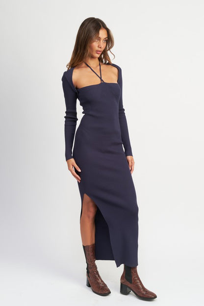 Woman wearing a long-sleeve navy dress with a slit on a white background