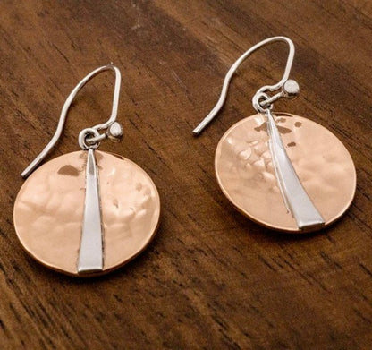Raw texture. Refined shine. These handcrafted earrings blend the warmth of hammered copper with the cool elegance of sterling silver. Designed for lovers of artisan detail and bold simplicity, they’re perfect for everyday wear or special occasions.