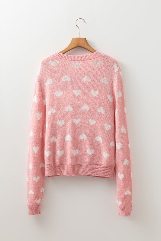 a heart button front sweater on a wall