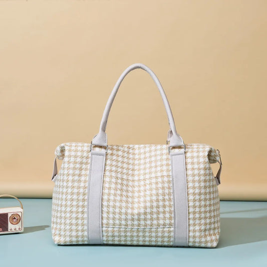 Beige and white houndstooth handbag with light gray handles and a structured, rounded shape. Soft and stylish—perfect for everyday fashion.