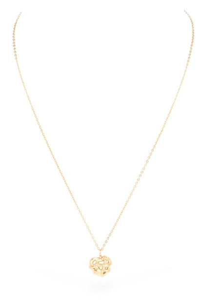 A gold necklace with a pendant in the shape of a heart, featuring an abstract design with cutouts.
