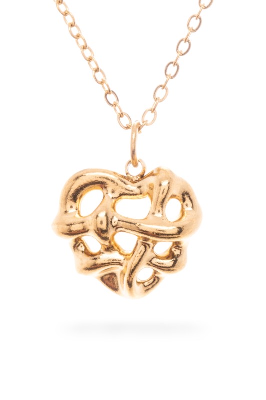 A gold necklace with a pendant in the shape of a heart, featuring an abstract design with cutouts.