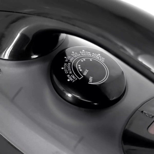 Close-up of a steam iron’s temperature dial labeled with fabric types—currently set to “MAX,” suitable for ironing heavy materials like cotton and linen.