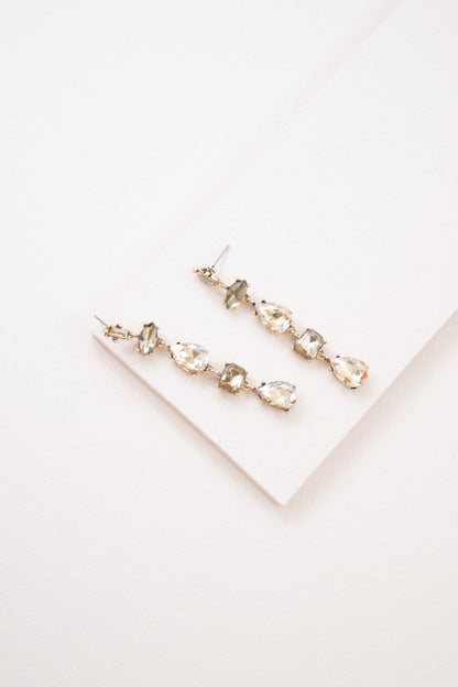 Glow like golden hour. These Iridescent Flare Dangle Earrings in golden tones are designed to catch the light with every move. Featuring a radiant iridescent finish and sleek drop silhouette, they’re perfect for weddings, parties, or adding a touch of glam to your everyday look.