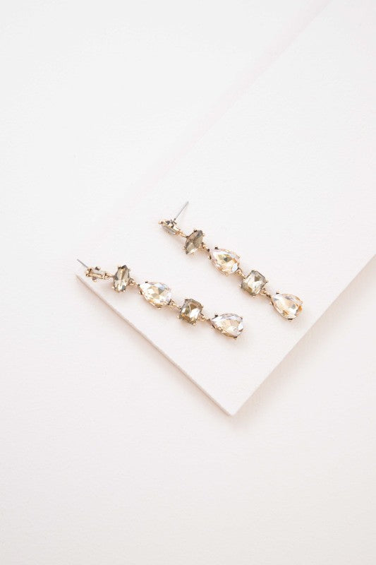 Glow like golden hour. These Iridescent Flare Dangle Earrings in golden tones are designed to catch the light with every move. Featuring a radiant iridescent finish and sleek drop silhouette, they’re perfect for weddings, parties, or adding a touch of glam to your everyday look.