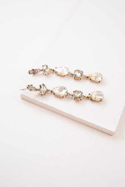 Glow like golden hour. These Iridescent Flare Dangle Earrings in golden tones are designed to catch the light with every move. Featuring a radiant iridescent finish and sleek drop silhouette, they’re perfect for weddings, parties, or adding a touch of glam to your everyday look.