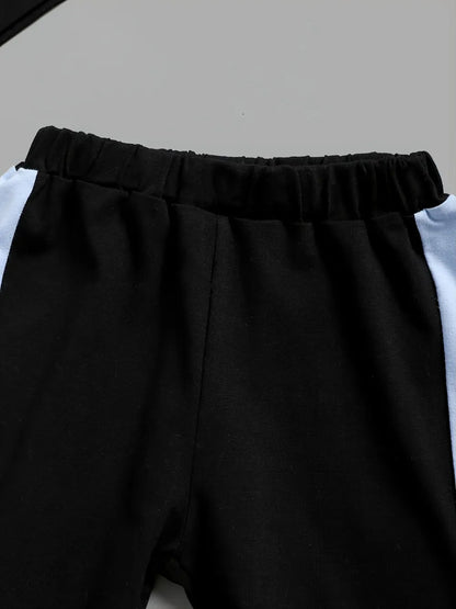 Black pants with a white shirt underneath on a light gray background