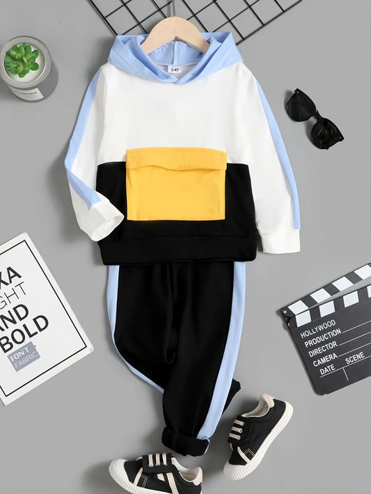 Children's outfit with a white and blue hoodie, black pants, and yellow pocket on a gray background.