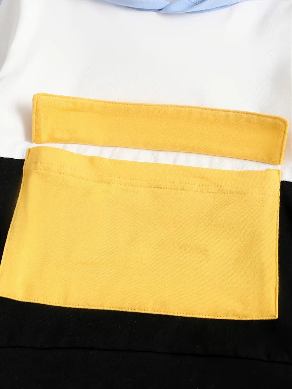 Close-up of a yellow pocket on a black and white garment
