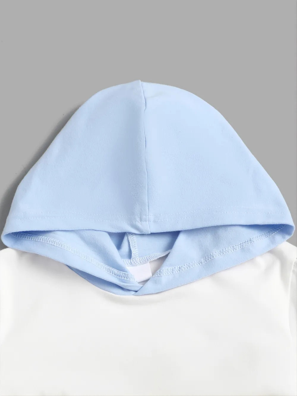 Light blue hood on a white garment against a gray background