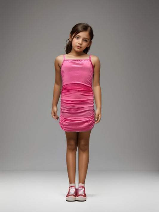 Young girl wearing a pink dress against a gray background