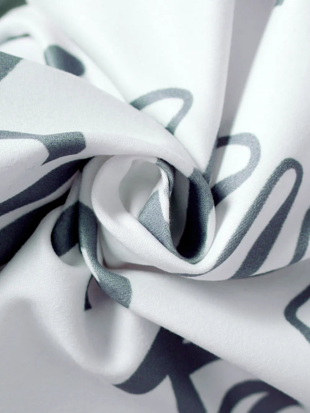 Close-up of fabric with black and gray abstract pattern on white background