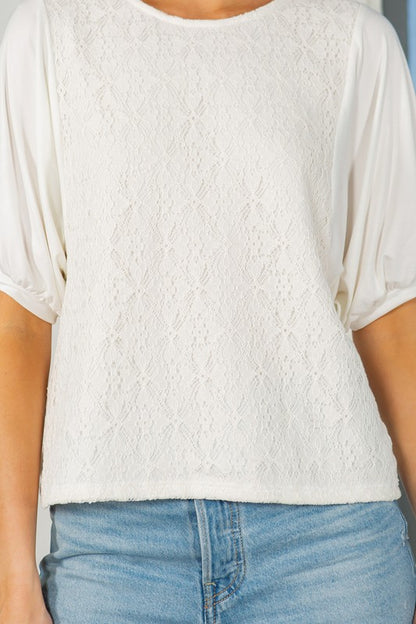 The lace overlay adds intricate detail; the puff sleeves bring statement style.