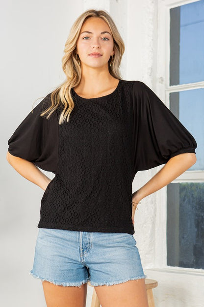 Light and airy, this top blends lace finesse with bold sleeve structure.