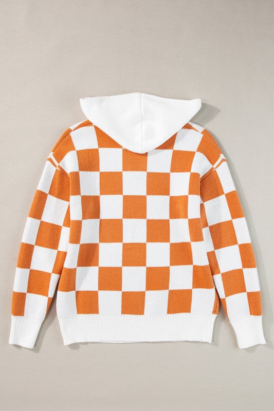 Orange and white checkered hooded sweater on a hanger, featuring a kangaroo pocket and a ribbed hem and cuffs, back view