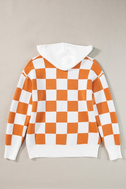 Orange and white checkered hooded sweater on a hanger, featuring a kangaroo pocket and a ribbed hem and cuffs, back view
