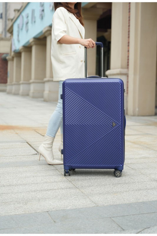 a durable hardshell suitcase with a modern geometric textured design and spinner wheels.