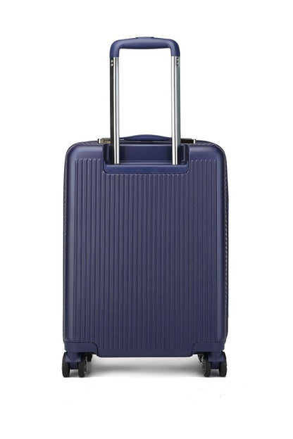 Dark blue hard-shell suitcase with vertical ribbed texture, extended telescopic handle, and four spinner wheels—standing upright on a wooden floor.