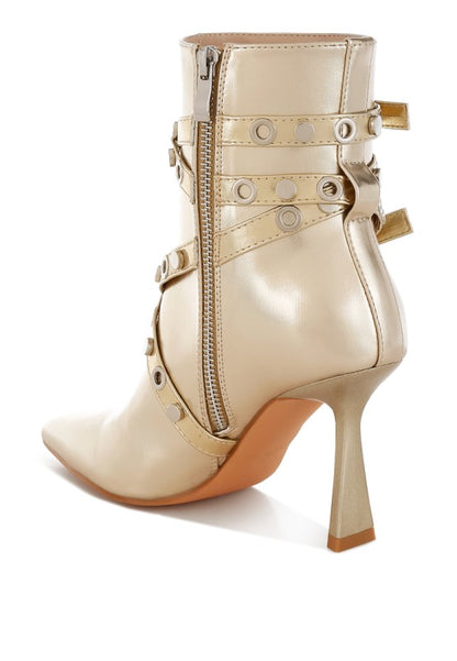 Beige high-heeled boot with studded details on a white background