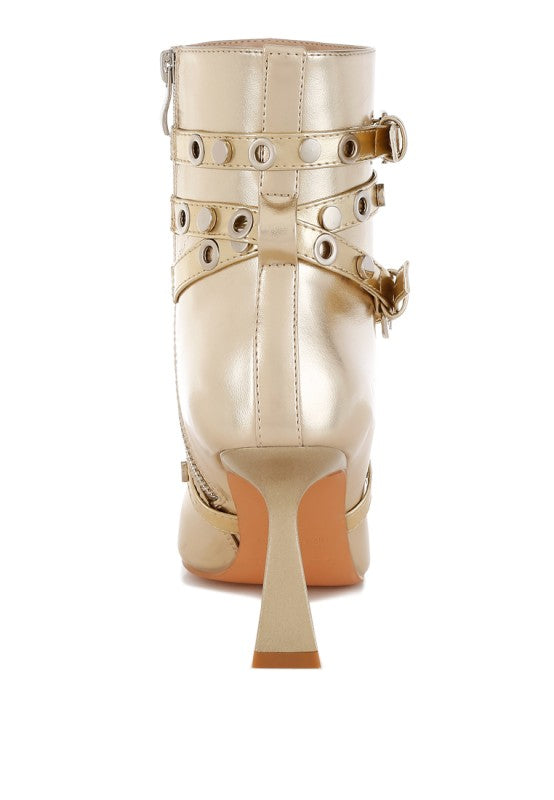 Beige high-heeled boot with gold buckles on a white background