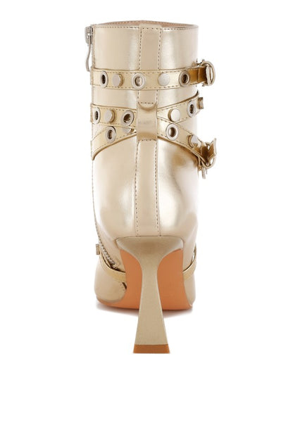 Beige high-heeled boot with gold buckles on a white background