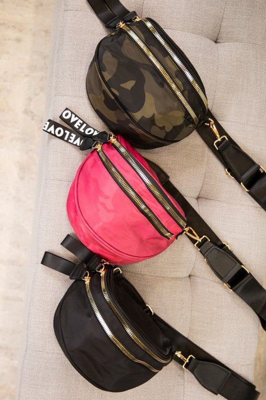 Set of three stylish crossbody/waist bags in camo green, pink camo, and black. Each features gold zippers, adjustable black straps, and a bold "LOVELOVE" tag, perfect for everyday wear with a street-style edge.