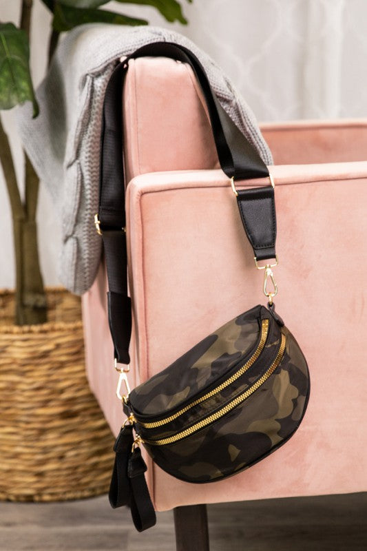 Camouflage-patterned crossbody bag with gold zippers and hardware, featuring a wide adjustable strap. Rugged yet stylish—perfect for casual, everyday wear.