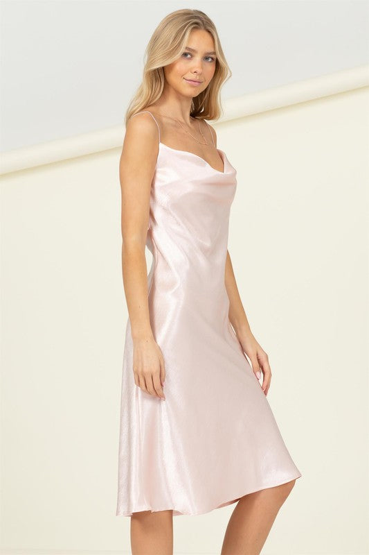 Woman wearing a satin cowl neck midi dress with spaghetti straps, styled against a light background.