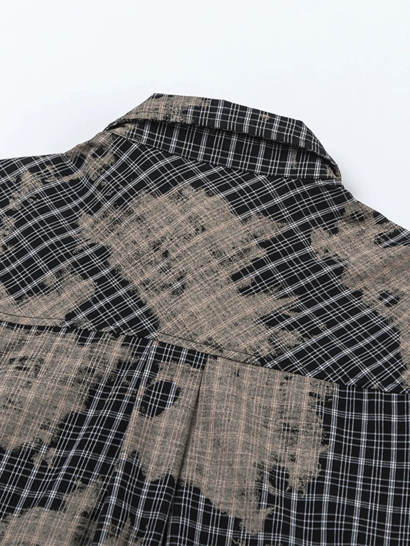 This men's button-down shirt features a distressed plaid pattern for a rugged, casual look and versatile wear.