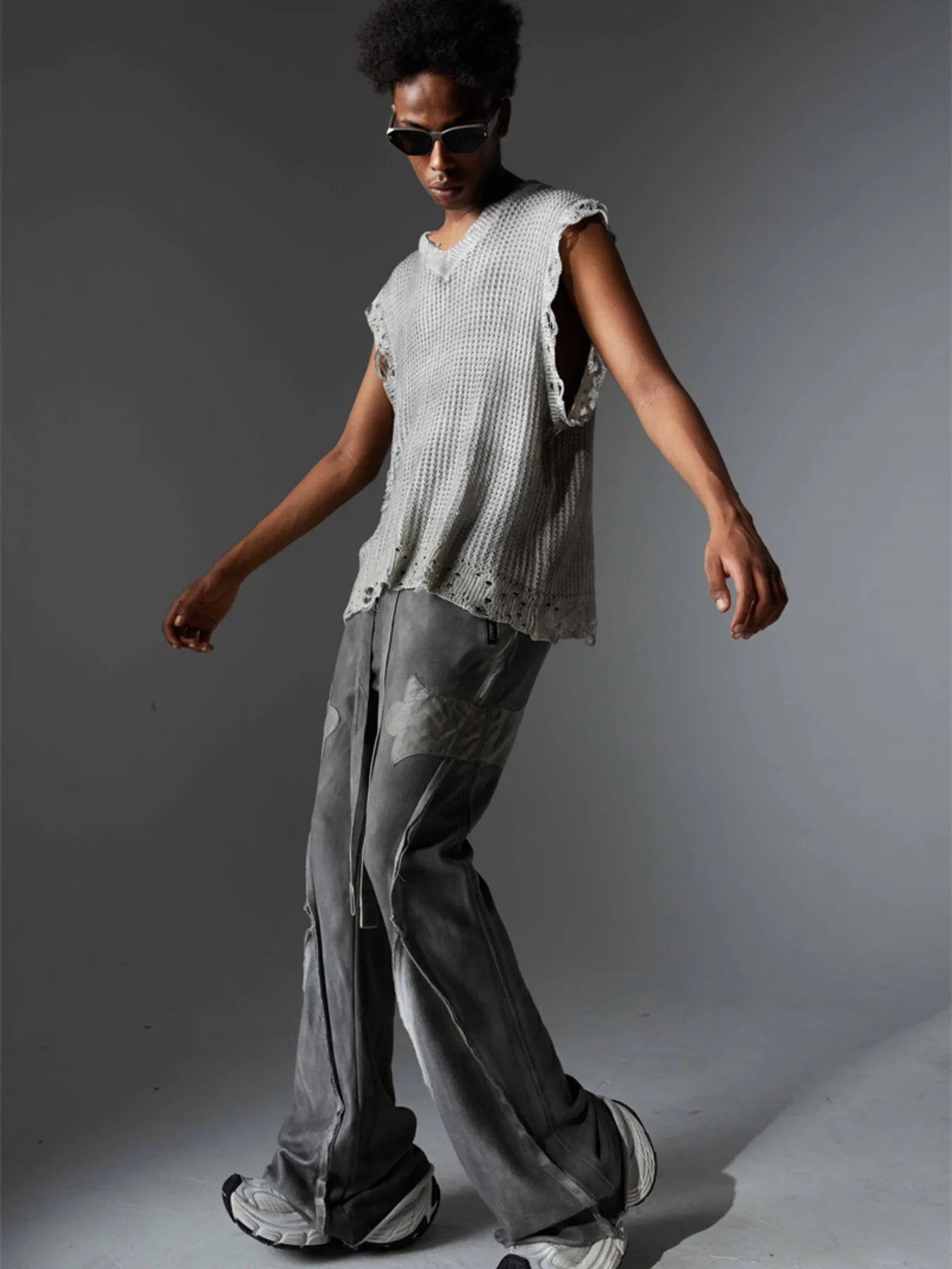 A stylish men’s distressed knit vest featuring intentionally frayed edges for a rugged, contemporary look.

