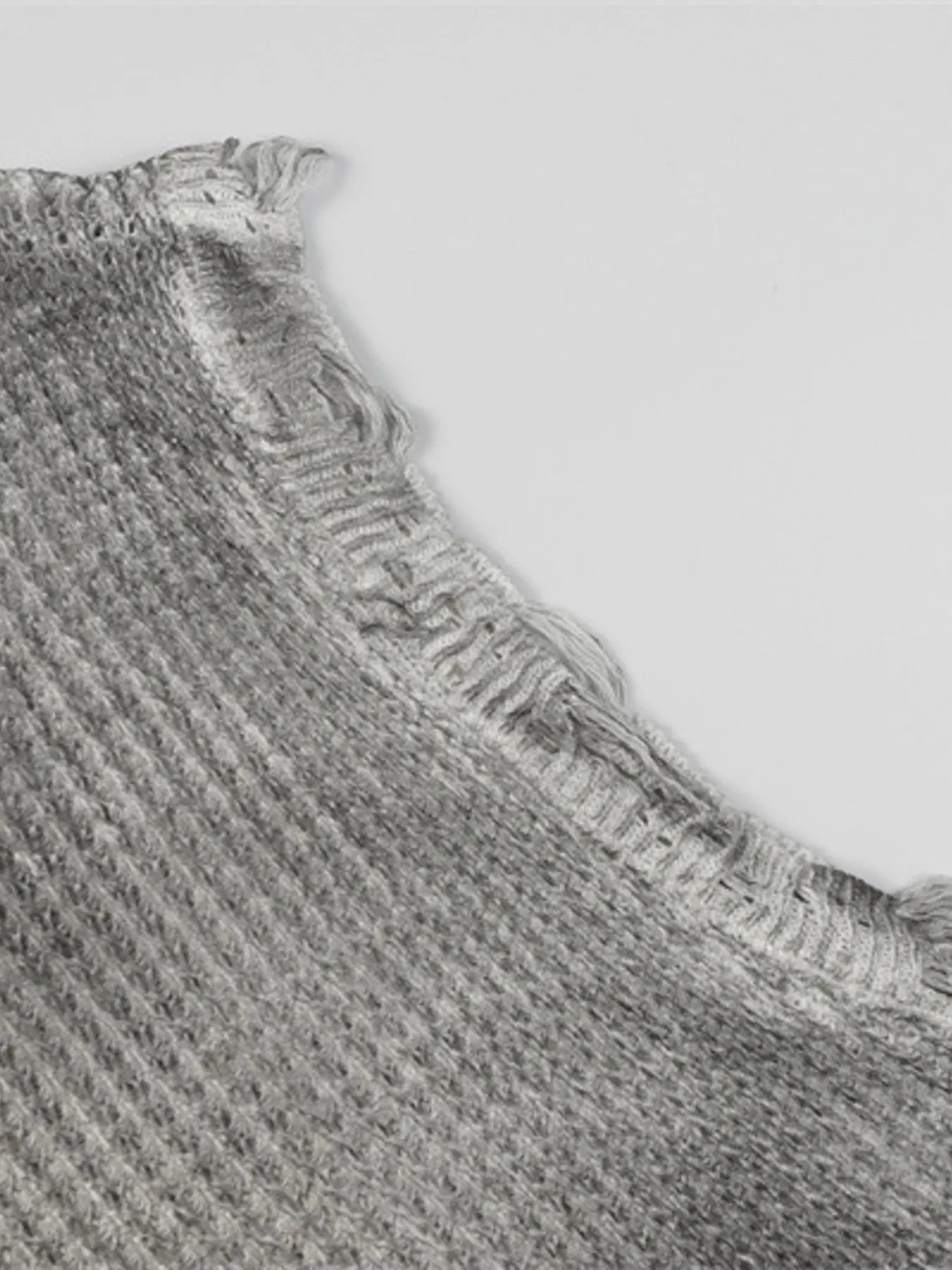 A stylish men’s distressed knit vest featuring intentionally frayed edges for a rugged, contemporary look.