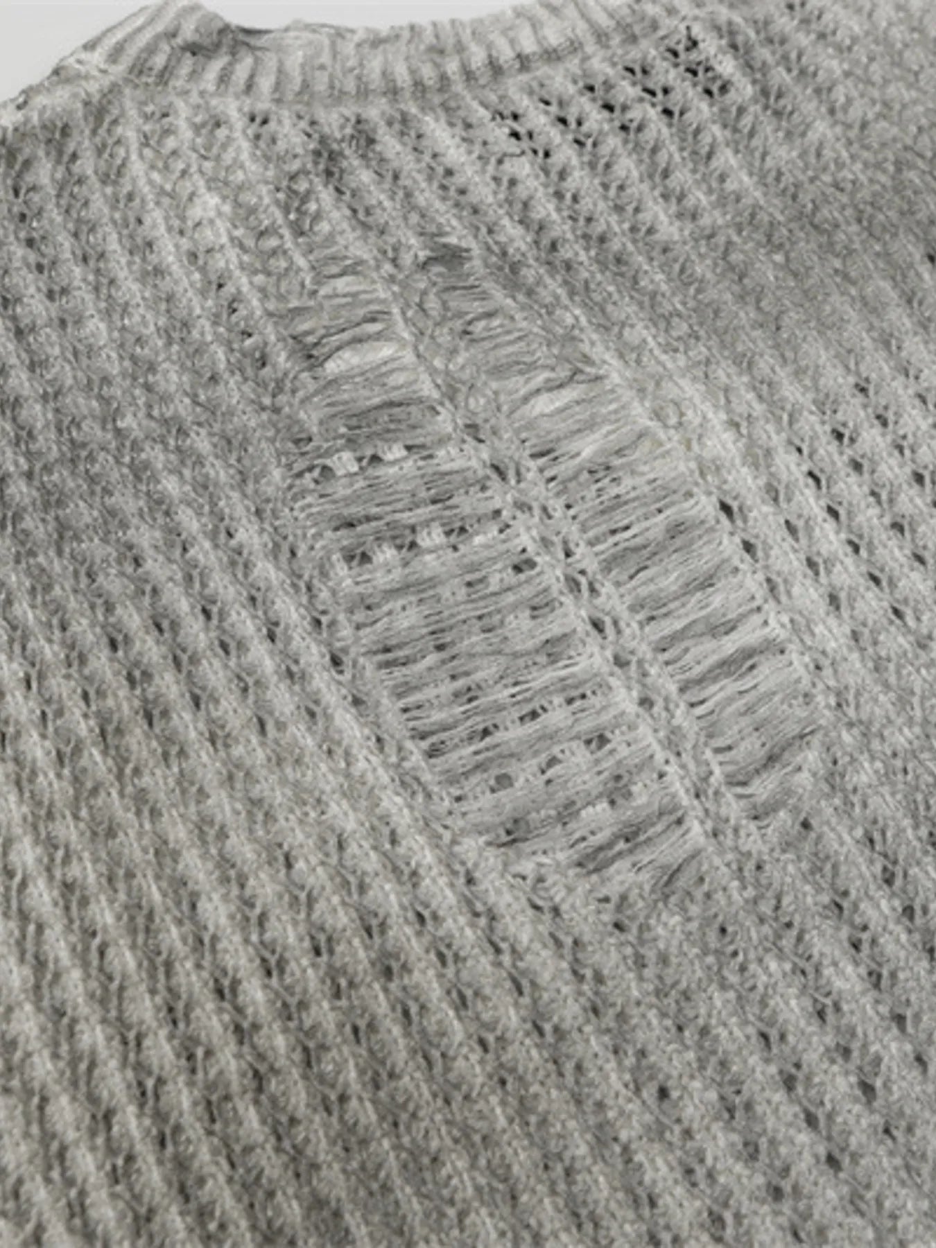 A stylish men’s distressed knit vest featuring intentionally frayed edges for a rugged, contemporary look.