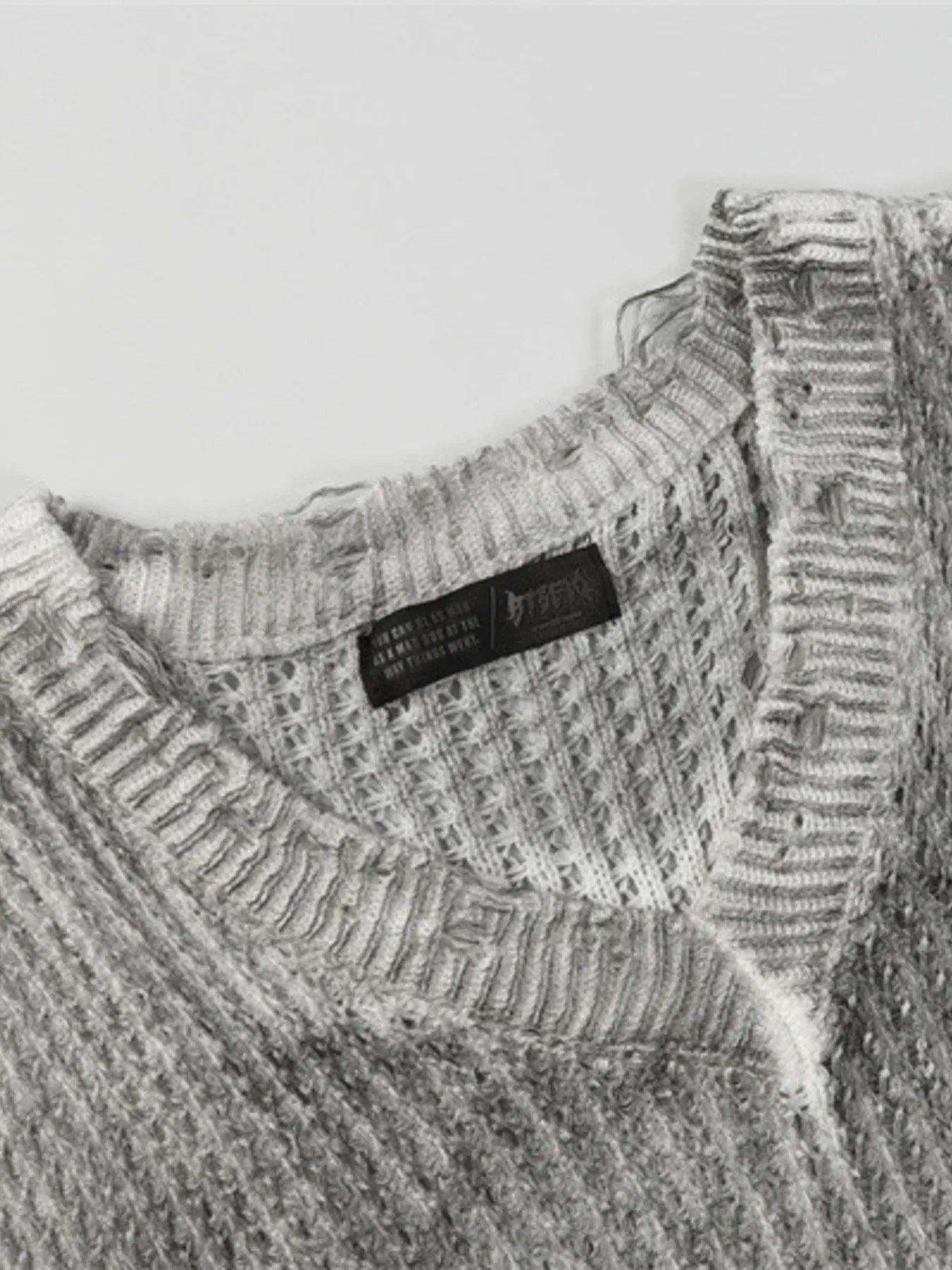 A stylish men’s distressed knit vest featuring intentionally frayed edges for a rugged, contemporary look.