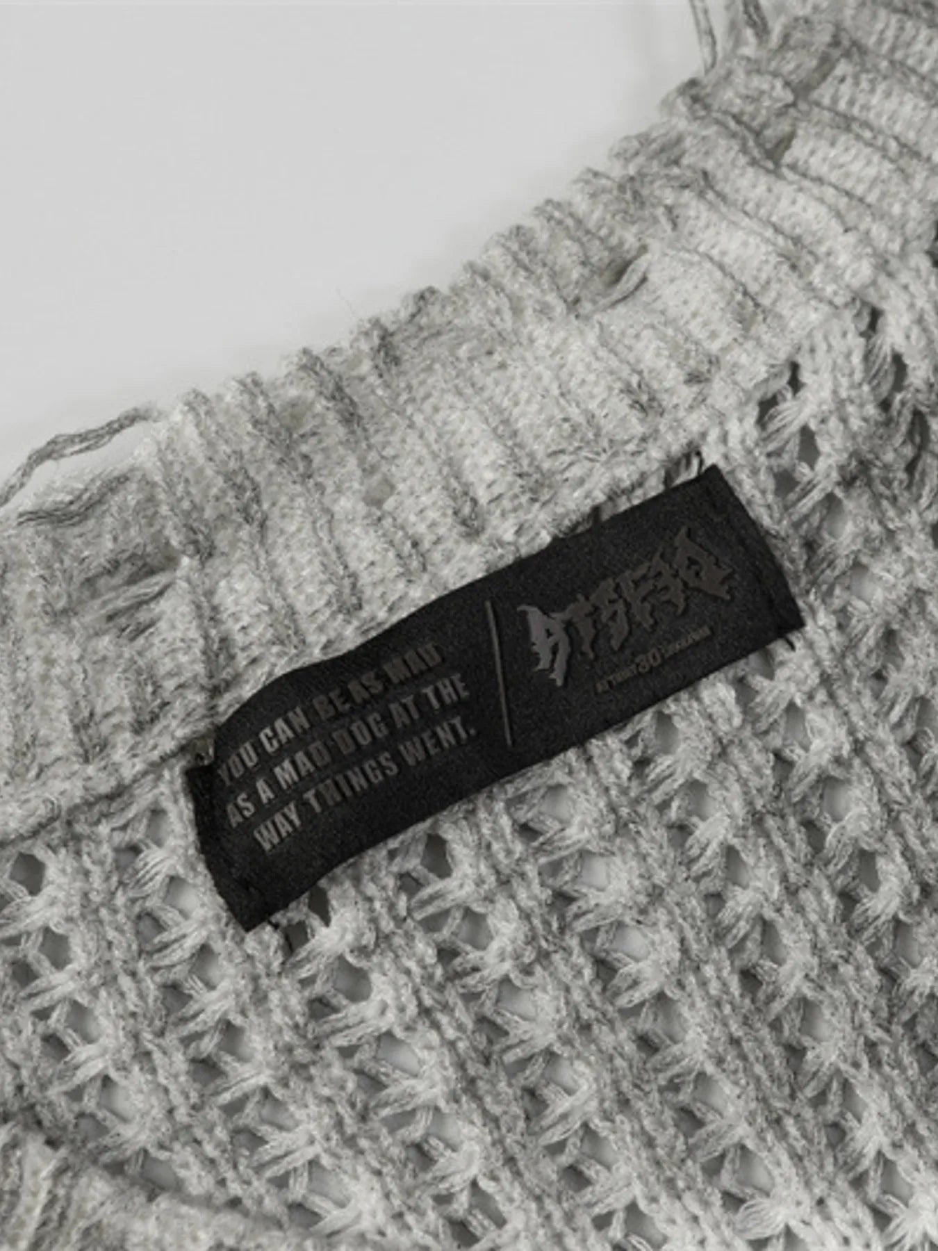 A stylish men’s distressed knit vest featuring intentionally frayed edges for a rugged, contemporary look.