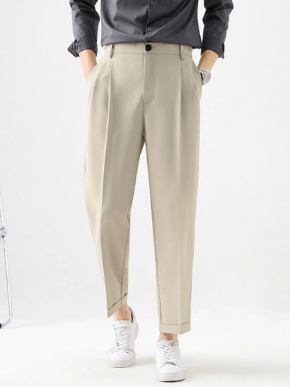 Person wearing beige pants and a dark shirt on a white background