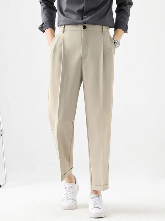 Person wearing beige pants and a dark shirt on a white background