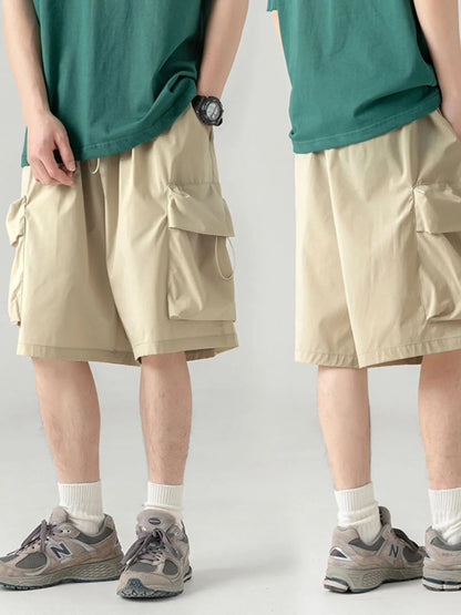 Two people wearing beige cargo shorts on a plain background