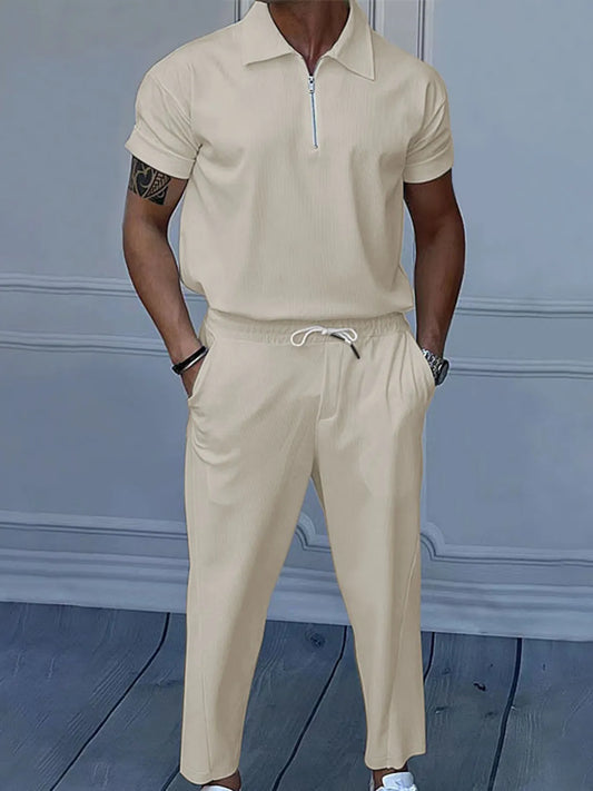 This is a plus-size men's two-piece set featuring a quarter-zip polo with short sleeves and matching pants, designed for comfortable, easy-wear versatility.