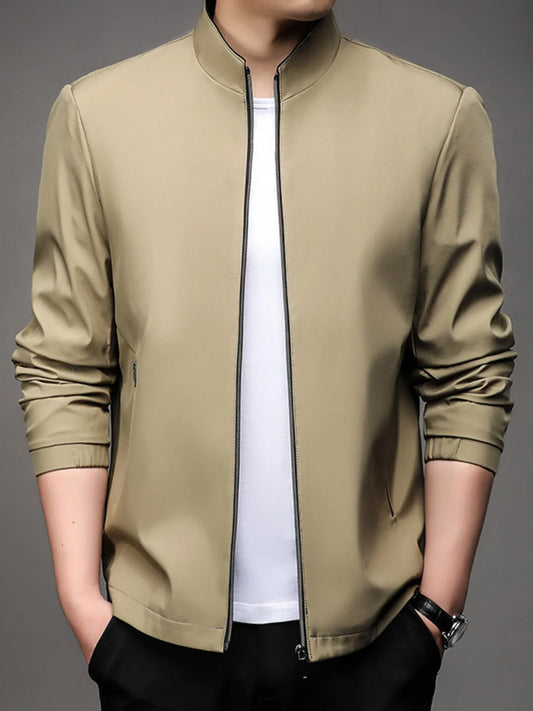 Men’s light brown zip up long sleeve jacket with side zipper pockets, worn over a white t-shirt