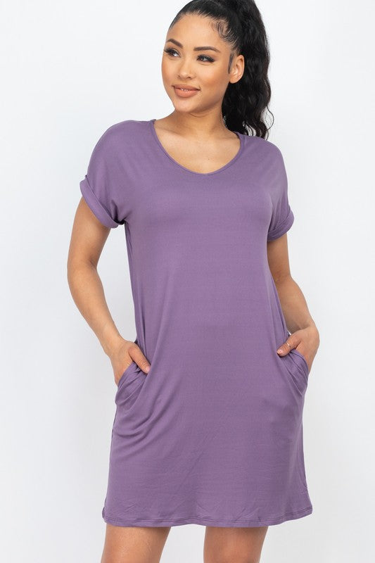 Woman wearing a purple dress with pockets on a white background