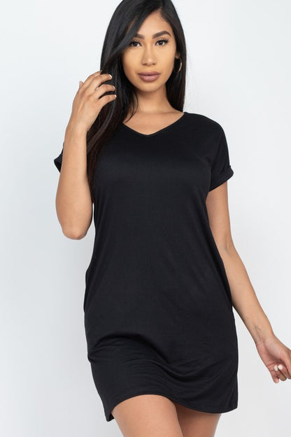 Woman wearing a black t-shirt dress against a white background